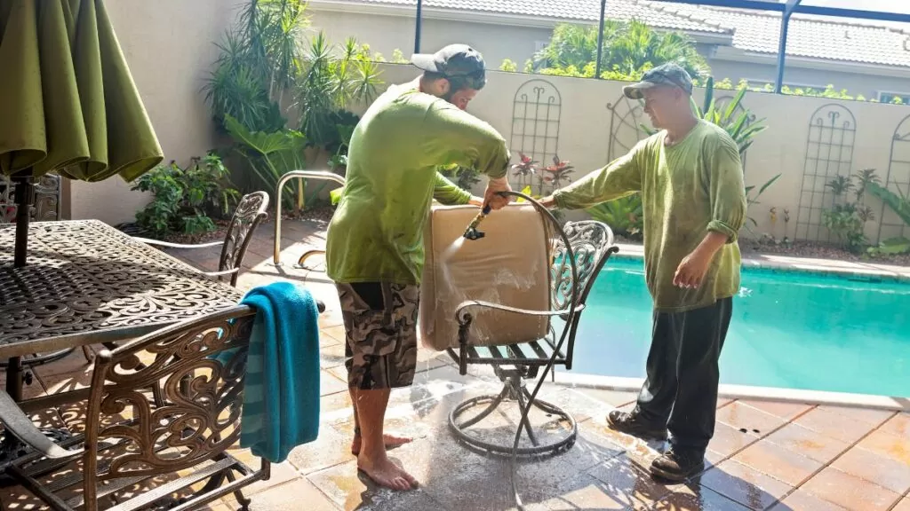 2 people washing a patio cushion