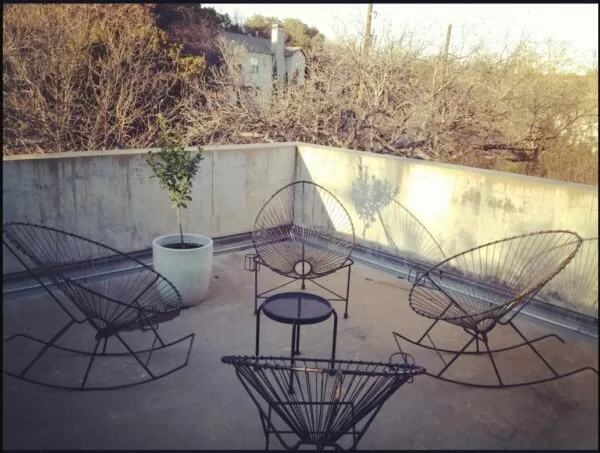 Black Acapulco rocking chairs on a patio