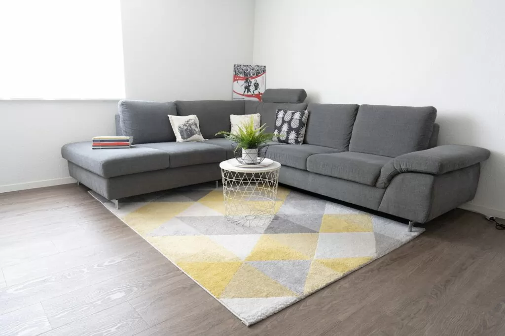 gray sectional couch beside yellow and white checkered table